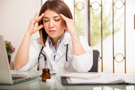 工作中头痛的年轻女医生图片