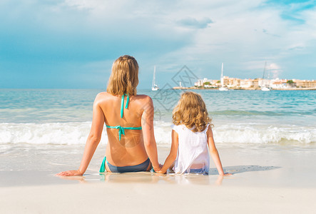 在海边晒日光浴的女人和小女孩图片