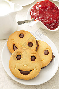 一块盘子一些微笑的饼干一锅加牛奶高清图片