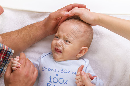 父母安抚一个哭着的婴儿图片