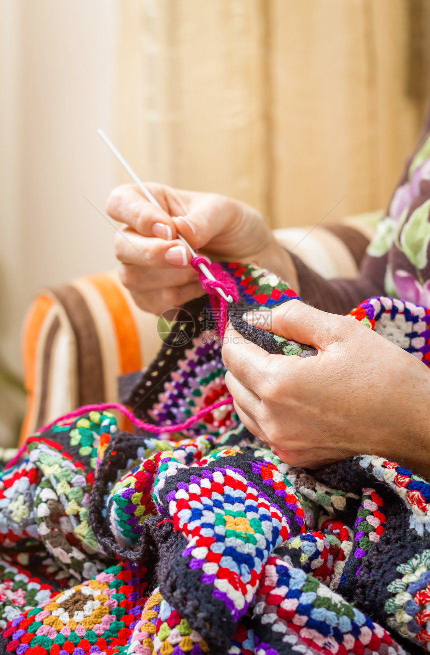 高龄女人的手织着长年羊毛涂图片