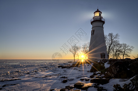 西北俄亥州史无前例的Marblehead灯塔座落在冰冻的伊利湖的岩石海岸一旁冬天在这里看到多彩的日背景图片