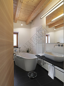 现代浴室中央有浴缸和木天花板图片
