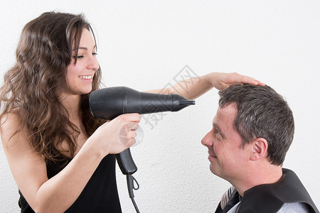 理发店的人用吹风机吹干头发图片