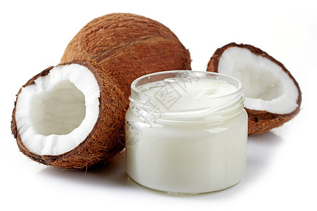 一罐椰子油和新鲜椰子用白色隔开图片
