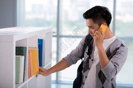 大学生在电话上聊天在图书图片