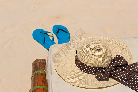 夏季沙滩上的草帽和人字拖图片