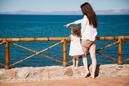 小女孩和她妈在外面放松从阳台看海的外图片