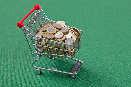 绿色表面购物篮蚂蚁中的硬币图片