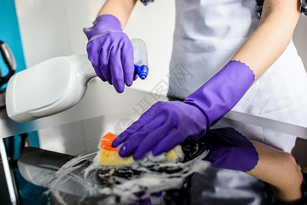 妇女用橡胶防护手套洗手清洗厨房顶部的图片