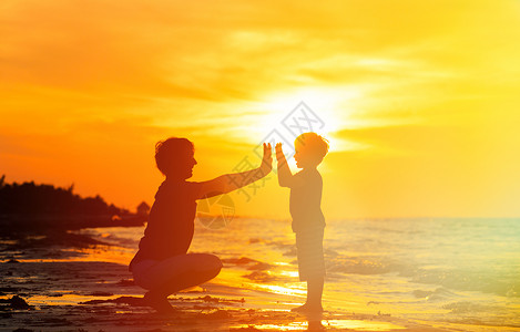 父亲和儿子在日落海图片