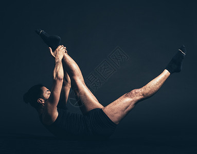 健康男子在地板上用黑色背景搭配大拖网瑜伽或SuptaParsva图片