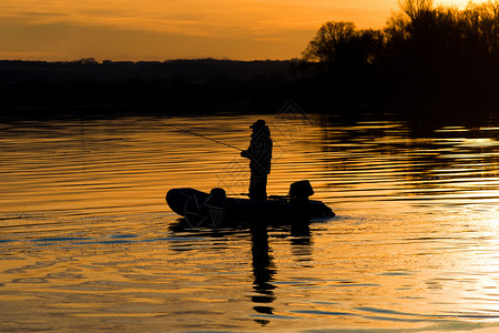 日落时在渔船钓竿图片