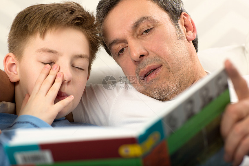 父亲给已经昏欲睡揉眼睛的儿子读图片