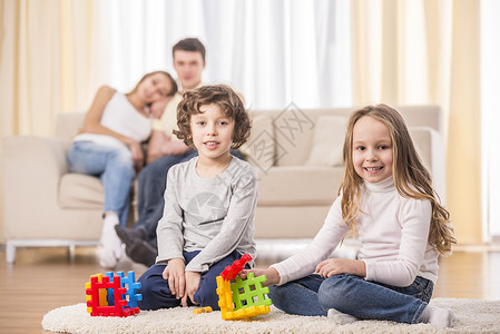 玩耍的孩子和父母一起在客厅里打米卡诺球图片