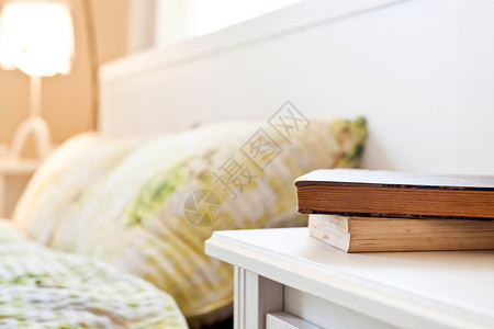 床头柜上有书的卧室背景图片