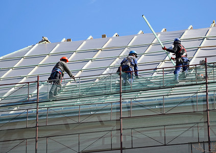 屋顶工在建筑物屋顶上工作图片