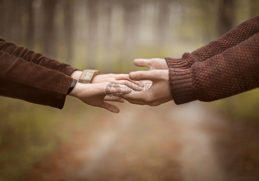秋天在公园里牵手的情侣特写图片