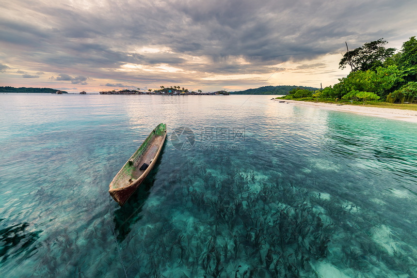 传统木制独木舟漂浮在印度尼西亚中苏拉威西岛偏远的托根群岛玛林格透明的绿宝石水面上图片