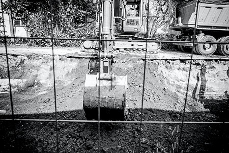 挖掘机在城市街道上挖一条深沟图片