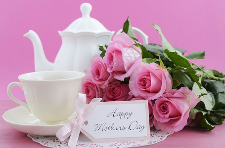 母亲节快乐粉红玫瑰茶壶和茶叶布置在陈年旧式的苦心高清图片