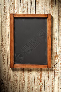旧木墙上垂直的旧黑板背景图片