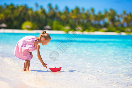 可爱的孩子在海里玩纸船图片