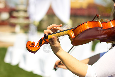 女孩在小提琴室户外玩耍婚礼的音乐家露天下的图片
