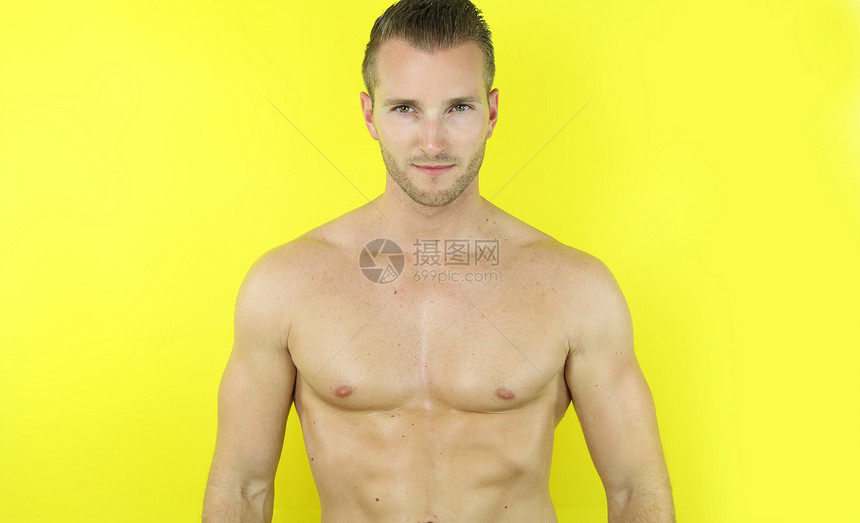黄色背景的英俊的肌肉人图片