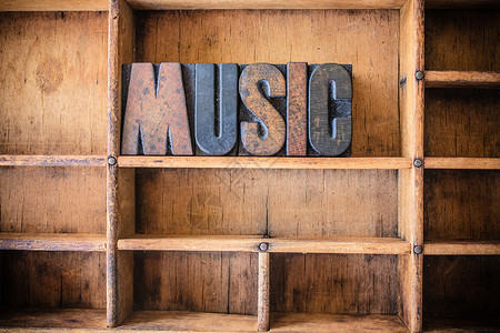 MUSIC这个词是用木制抽屉里的旧木制纸质背景图片