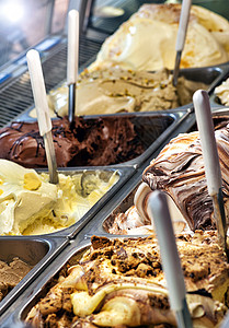 在商店或冰淇淋店的金属托盘中展示各种美味的新鲜冰淇淋口味图片