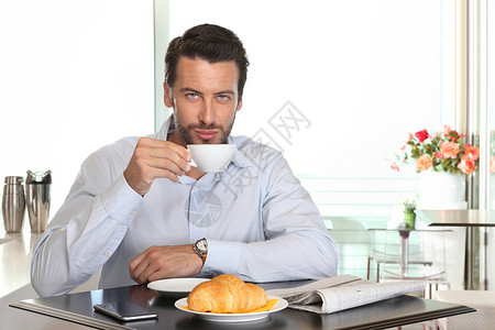男人在咖啡馆喝咖啡与牛图片