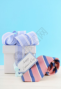 白蓝丝带红蓝色条纹领带白木桌上的礼品标签和苍白蓝背景Bquablue图片