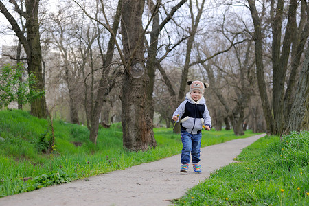 一个小男孩在春公园周围拿图片