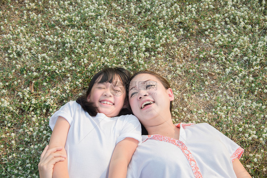 亚裔孩子和母亲躺在花草上图片