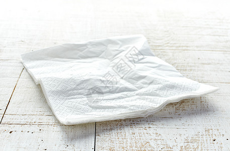 白色木桌上有褶皱的餐巾纸图片
