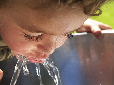 小男孩从饮用水喷泉里图片