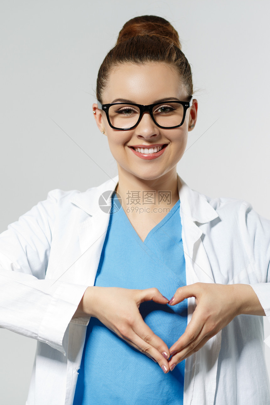戴着眼镜的美丽微笑女医生用手显示心形医生的手特写医疗帮助预防或保险概念心脏病学护理健康图片