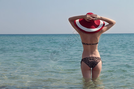 穿着太阳帽和比基尼的感美女站在她的双臂举到头上图片