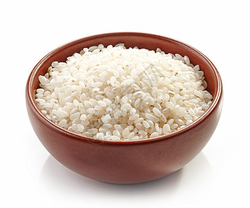 一碗未煮过的圆形米饭在白色背景下被隔离图片