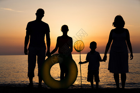 幸福家庭的剪影在海滩的图片