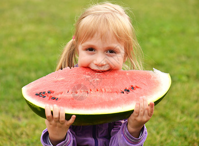 可爱的小女孩在户外吃西瓜图片