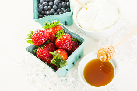 用原味酸奶和新鲜浆果在桌子上制作冰沙的原料图片