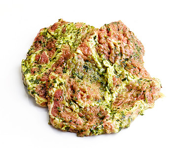 在白色背景上隔离的绿色腌料中的生肉切块图片