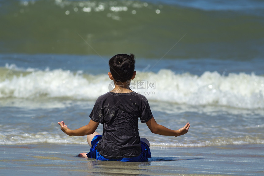 一个浑身湿透的年轻男孩正在杜顿纳海滩附近的图片