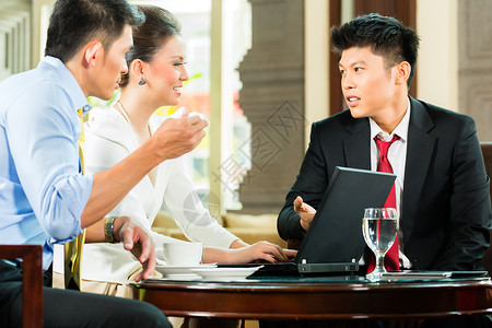 三名亚洲华人办公室人员或商人和女商人在酒店大堂举行商务会议图片
