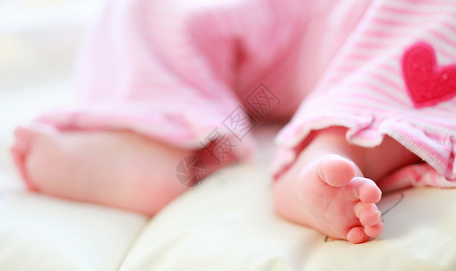 可爱的婴儿脚在婴儿床图片