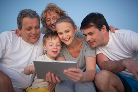 快乐的大家庭在一起玩得很开心祖父母和父母在男孩使用平板图片