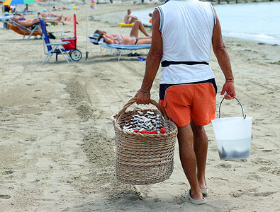 男人在海滩上卖水果用椰子草莓和甜瓜图片