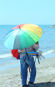 夏日海边卖彩伞的老头图片
